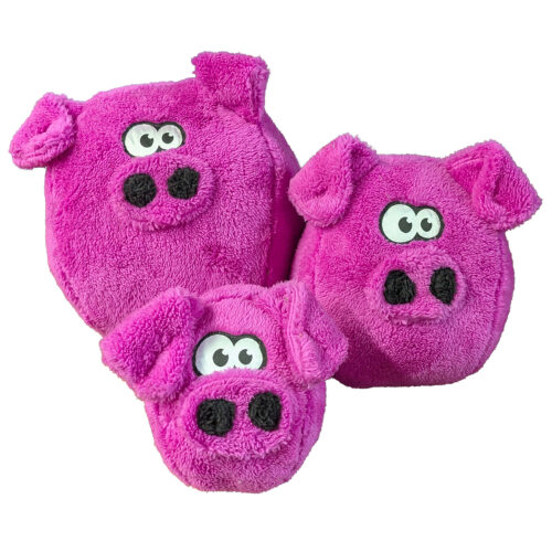Pair of bright pink plush pig slippers with black noses and cartoon eyes used for indoor wear.